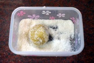 趁热取出糯米球，放入椰丝中滚几下，整体沾满椰丝即可。