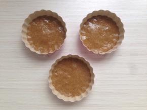 将饼干分成3份，放在法焙客的活底圆形蛋挞模具里，用汤匙压平、压紧，放冰箱冷藏备用