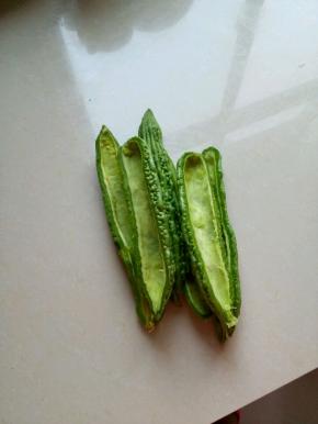 苦瓜洗净对半切开，挖掉里面的籽和白膜