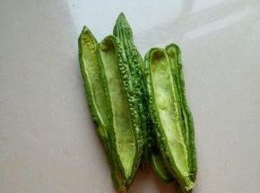 苦瓜洗净对半切开，挖掉里面的籽和白膜