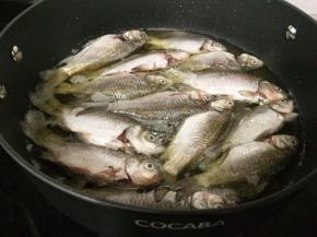 油温七成热时放入鱼，小火炸制。