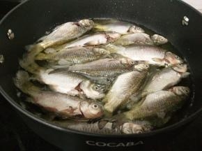 油温七成热时放入鱼，小火炸制。