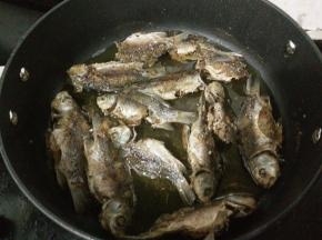 等鱼凉了之后，再次烧热锅里的油放入鱼，大火炸至金黄后翻面继续炸。