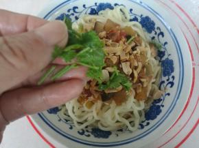 面装碗，浇上切丁卤，撒上碎花生，点缀香菜即可。