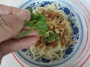 面装碗，浇上切丁卤，撒上碎花生，点缀香菜即可。