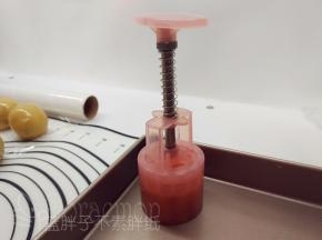 月饼模连带面团转移到烤盘上，竖起月饼模，稍加用力按压。