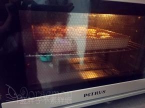 将全部印好的月饼连带烤盘，送入预热好的烤箱，上下火200℃，中层，烘烤5分钟，让月饼花纹定型。