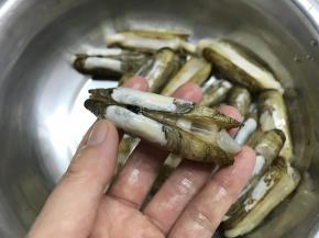 用刀在蛏子背部划上一刀，不要切断。