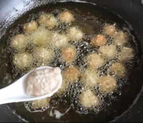 锅中多放油烧热，筷子放进去有密集油泡就可以放萝卜肉丸了，左手利用虎口挤肉丸，右手用汤匙把肉丸放进锅里炸