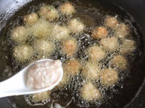 锅中多放油烧热，筷子放进去有密集油泡就可以放萝卜肉丸了，左手利用虎口挤肉丸，右手用汤匙把肉丸放进锅里炸