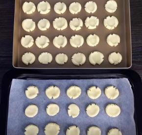 分别揉成小的圆球，放在铺上油纸的烤盘上，用大拇指轻轻压扁，自然散开，全部做好，整整两烤盘（如果做一盘，量减半）