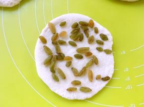 均匀的撒上葡萄干，再将第二份面团擀成圆片，盖在铺好葡萄干的面团上，大小尽量跟第一片相同