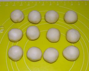 将醒好的油皮面团用手压扁，包裹油酥皮面团，用虎口一点点收好口