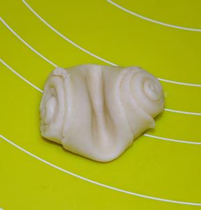 将醒好的面团从中间压一下，然后压扁