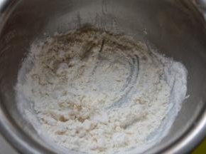 混合油酥皮材料，用手蘸点面粉捏猪油，直至混合成面团