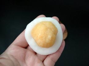 捏出小窝，放上一份25克的南瓜馅。