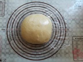 取出面团轻压排气，滚圆盖上保鲜膜松弛15分钟，整形过程中面包机按暂停，中途启动后再次按暂停