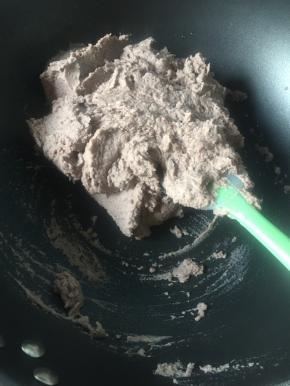 将打好的红豆泥放入不粘锅中小火炒，要有耐心，因为本来打的红豆泥比较干，很容易就炒到成团了