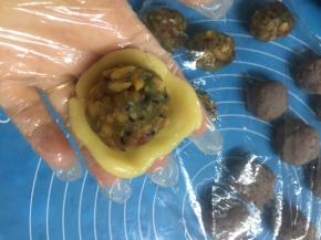月饼皮搓圆压扁，放入馅