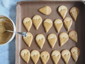 将200g糖粉和一个蛋清打发成糖霜，将其中一部分调成褐色，涂上冰淇淋的蛋筒部分