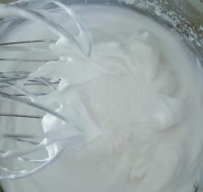 继续打发蛋白出现纹路后转低速打至稍有阻力时，提起打蛋器呈现直立的小尖角即可