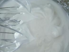 继续打发蛋白出现纹路后转低速打至稍有阻力时，提起打蛋器呈现直立的小尖角即可