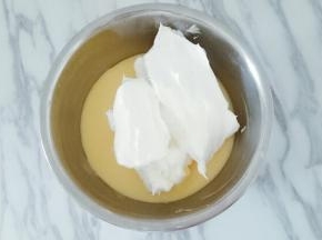 取三分之一的蛋白加入蛋黄糊中，上下翻拌均匀，不要画圈搅拌避免消泡