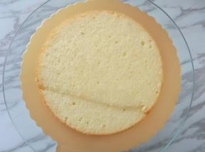 蛋糕地板中心抹少许奶油，放1片蛋糕