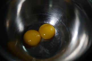 先分离两颗鸡蛋，蛋黄取出来，蛋白放入无水无油的另一个打蛋盆内