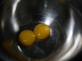 先分离两颗鸡蛋，蛋黄取出来，蛋白放入无水无油的另一个打蛋盆内