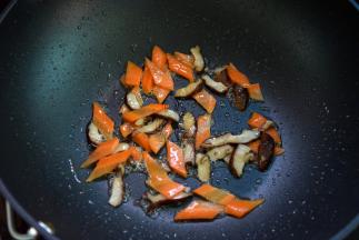 锅中留油，先炒一下香菇，再倒入胡萝卜稍炒