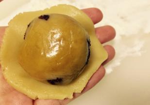 将分好的球状月饼皮擀成薄片，放入月饼馅（图片为其他口味馅料，参考方法即可）