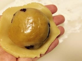 将分好的球状月饼皮擀成薄片，放入月饼馅（图片为其他口味馅料，参考方法即可）