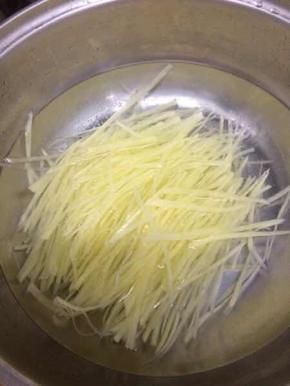 锅里加入适量的水烧开，将土豆丝放入锅中焯水六七分钟左右