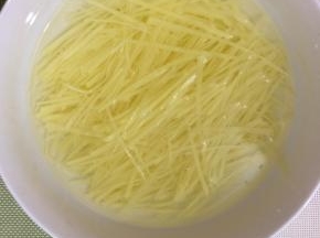 切好的土豆丝放入水中，多冲洗几次