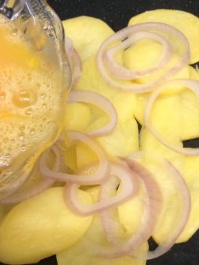 洋葱圈变软时，将鸡蛋液均匀的倒在上面