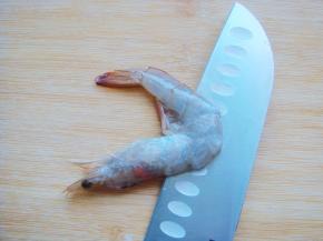 虾平方在栈板上，顺着虾背横切一刀，不要切断。