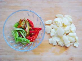 大蒜用刀背压碎，青红椒切小段备用。