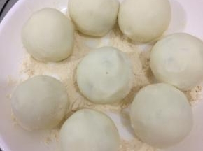 包好的土豆月饼坯放入熟面粉中沾一些面粉