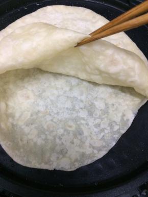 煎到看见鼓起来即可，用筷子从边上挑起，就是两张单饼