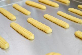 装入裱花袋。在烤盘上挤出长条装。两端要收圆。喷水雾后可以用叉子划出纹路。