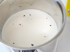 香草荚用刀划开刮出香草籽，加入牛奶中。剖开的香草荚也一起丢进去