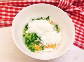 碗中打入鸡蛋，加入面粉、清水、葱花和适量盐