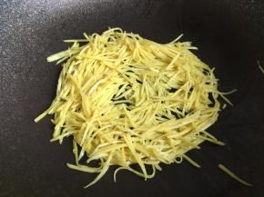 把炒软的红薯丝均匀摊放在锅内