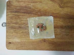 放上第三张馄饨皮，刷上蛋液，中间放上肉馅。