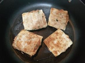 一面煎成金黄色后翻面，另一面也煎至金黄。