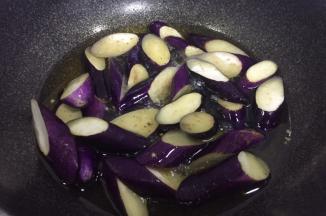 然后下茄子炸制茄子变软，捞出控油