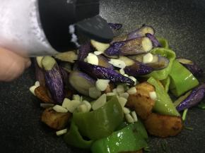 加入茄子，蒜末，盐翻炒均匀