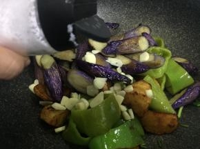 加入茄子，蒜末，盐翻炒均匀