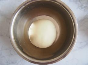 将揉好的面团放入容器中，盖上保鲜膜发酵至2倍大